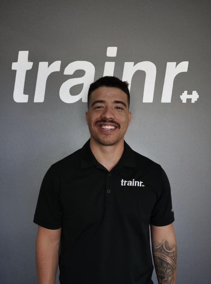 Trainr coach standing in front of Trainr branding